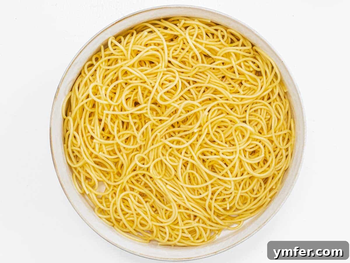 Vibrant Spaghetti Toss 5 Freshly cooked spaghetti being rinsed under cold water to cool it down for the salad.