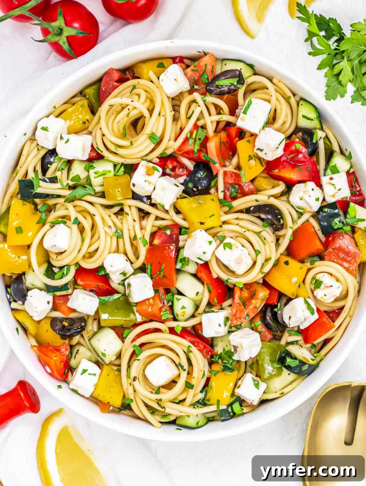 Vibrant Spaghetti Toss 9 A close-up of the cold spaghetti salad in a serving bowl, garnished with fresh herbs.