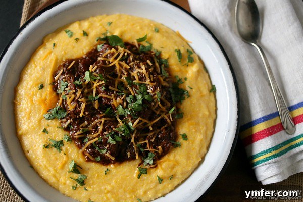 Short Rib Chili by Nutmeg Nanny A delicious bowl of Short Rib Chili carefully spooned over a bed of creamy polenta, ready to be enjoyed.