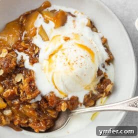 Caramel Apple Crisp ready to be served, topped with melted vanilla ice cream.