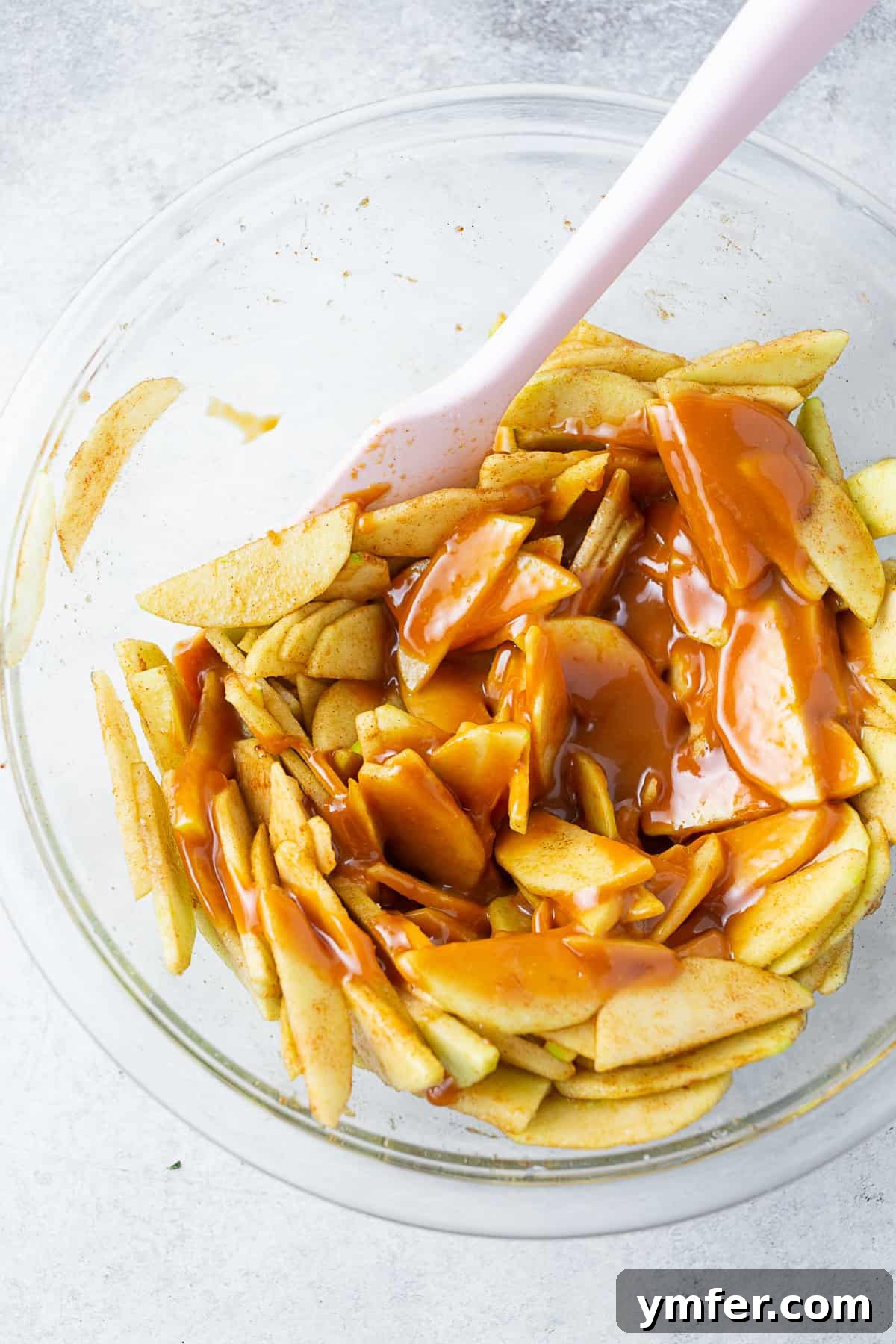 Sticky Caramel Apple Delight 4 Sliced spiced apples in a bowl topped with melted caramel sauce.