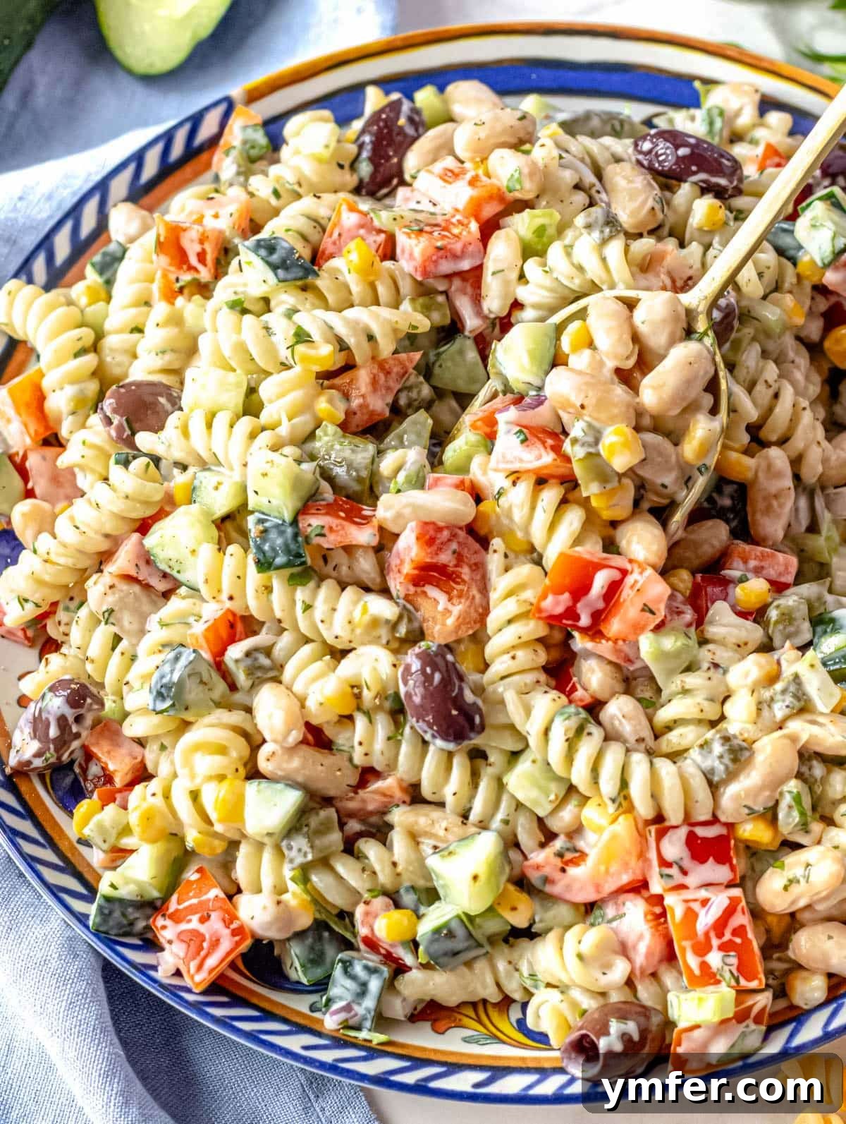 Velvety Pasta Salad 6 Creamy pasta salad beautifully arranged on a blue platter, garnished with fresh herbs.