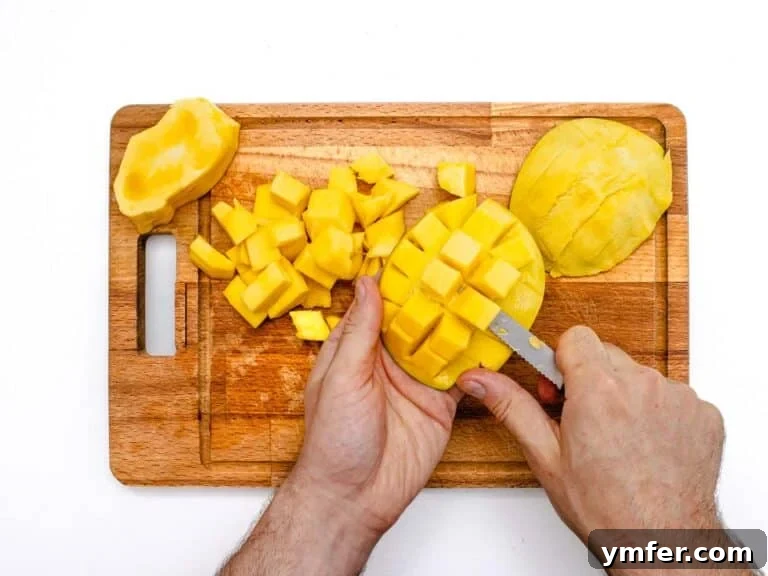 Removing diced mango from its peel