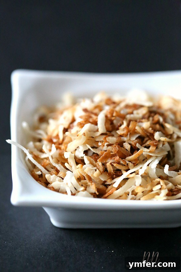 Toasted Coconut Tiramisu by Nutmeg Nanny Close-up of golden toasted coconut flakes in a small white bowl, ready to be incorporated into the tiramisu recipe.