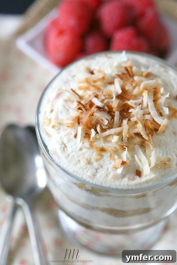 Toasted Coconut Tiramisu by Nutmeg Nanny A close-up of a single serving of Toasted Coconut Tiramisu in a small glass dish, garnished with additional toasted coconut flakes, ready to be enjoyed.