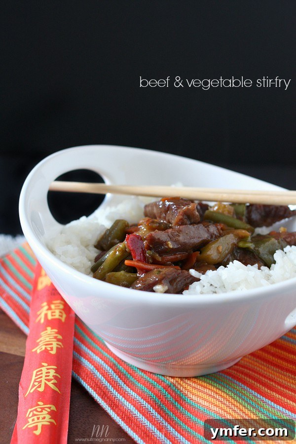 Easy Beef and Vegetable Stir-Fry by Nutmeg Nanny A vibrant bowl of Easy Beef and Vegetable Stir-Fry served with fluffy white rice and chopsticks, highlighting tender beef and crisp, colorful vegetables.