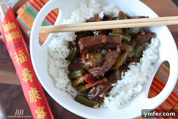 Easy Beef and Vegetable Stir-Fry by Nutmeg Nanny Close-up shot of a large white serving bowl brimming with Beef and Vegetable Stir-Fry, showcasing the rich sauce and perfectly cooked ingredients.