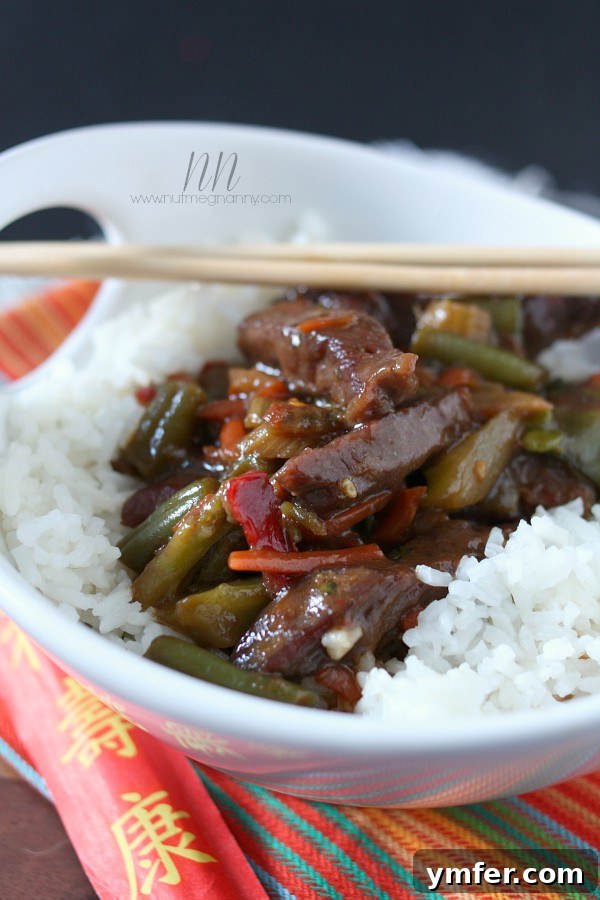 Easy Beef and Vegetable Stir-Fry by Nutmeg Nanny A freshly prepared bowl of Beef and Vegetable Stir-Fry beautifully plated over a bed of white rice, ready to be enjoyed.