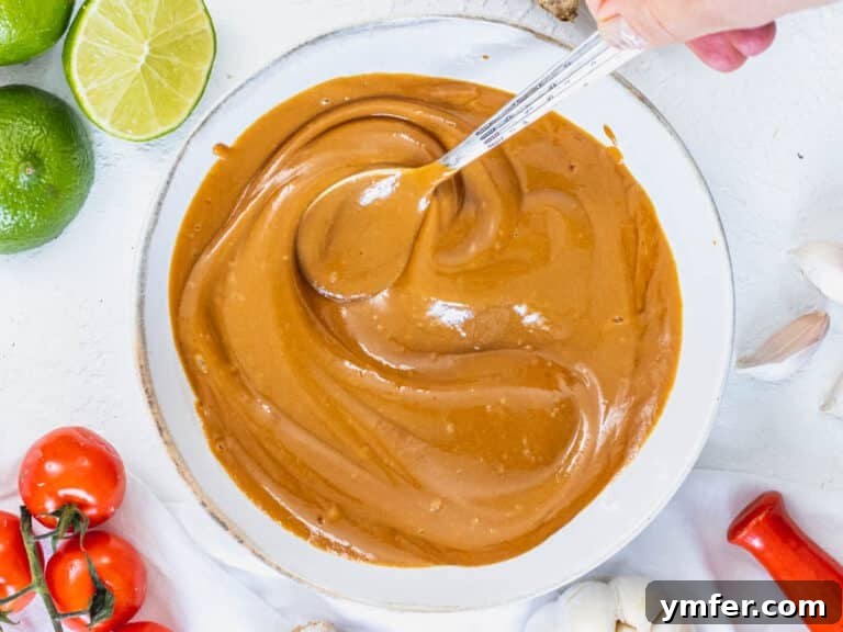 Peanut sauce in a white bowl with a spoon