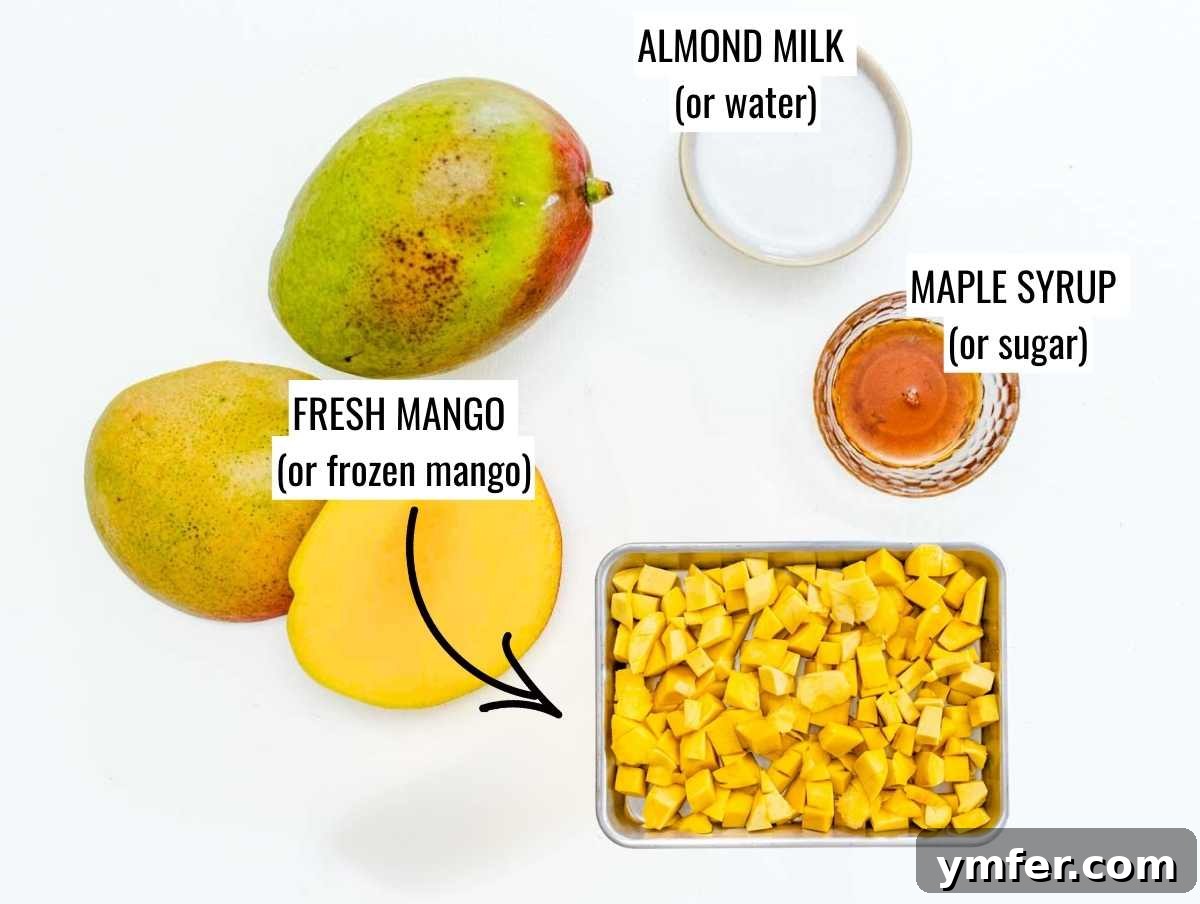 Fresh and frozen mango chunks, a small bowl of sugar, and a glass of almond milk, representing the ingredients for mango sorbet.