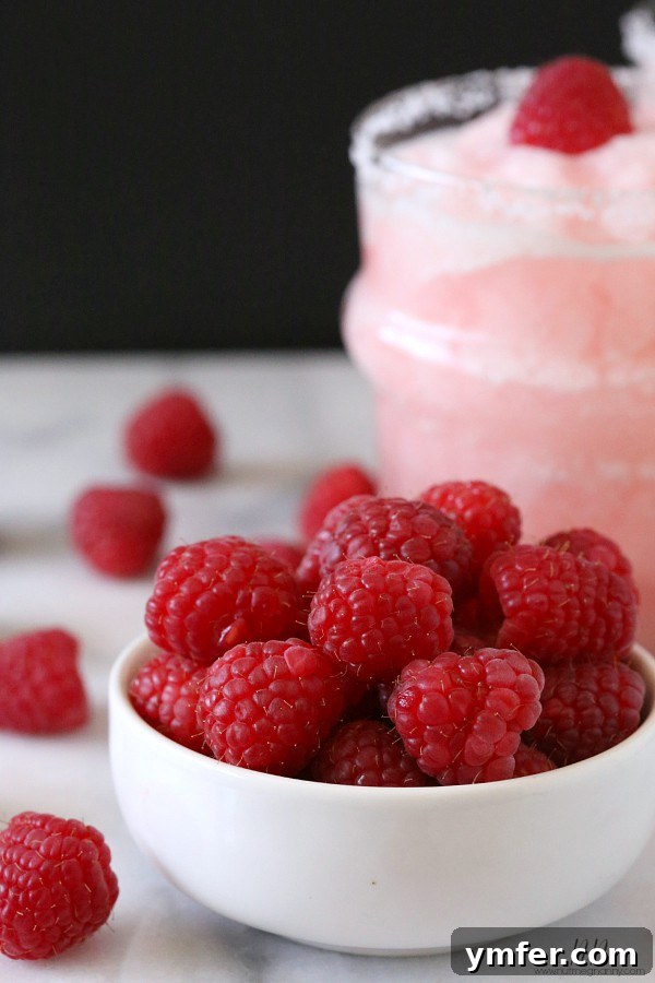 Raspberry Acai Frozen Margarita by Nutmeg Nanny Close-up of a vibrant Raspberry Acai Frozen Margarita with fresh raspberries