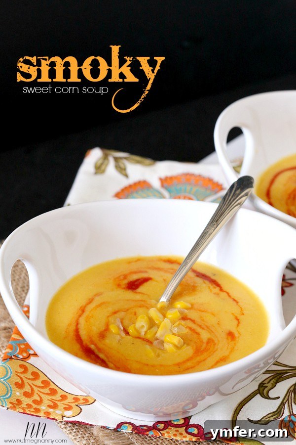 Smoky Sweet Corn Soup by Nutmeg Nanny A bowl of creamy Smoky Sweet Corn Soup, garnished with a swirl of sriracha and fresh herbs