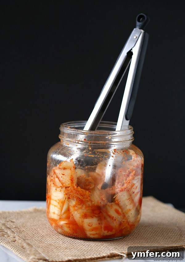 Kimchi Fried Rice by Nutmeg Nanny A glass jar filled with vibrant red kimchi, ready to be used in cooking.