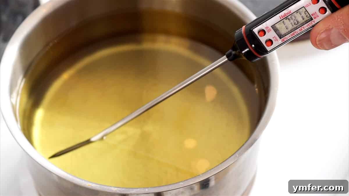 Using a thermometer to accurately measure the frying oil temperature.
