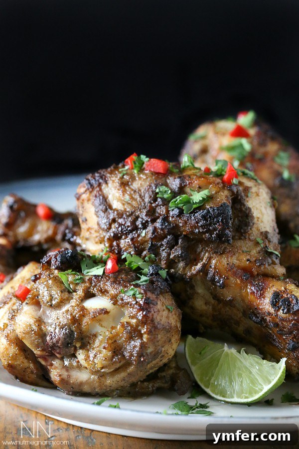 Authentic Jamaican Jerk Chicken 4 Grilled Jamaican Jerk Chicken drumsticks, garnished with fresh lime and cilantro