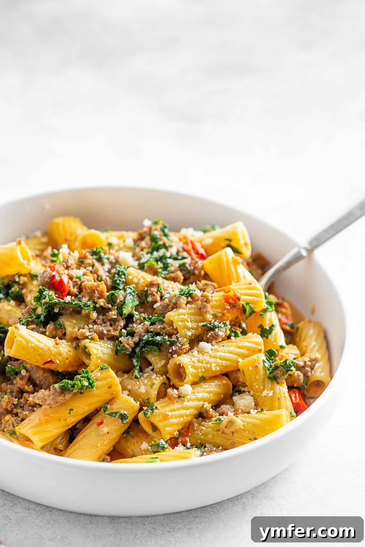 Italian Sausage Kale Pasta in a bowl with a fork.