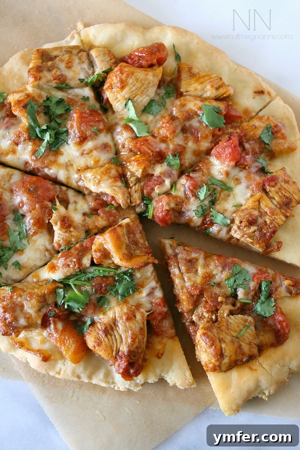 Indian-Inspired Gluten-Free Chicken Tikka Masala Pizza 3 Close-up of Gluten-Free Chicken Tikka Masala Pizza showing chunks of chicken, sauce, and melted cheese.