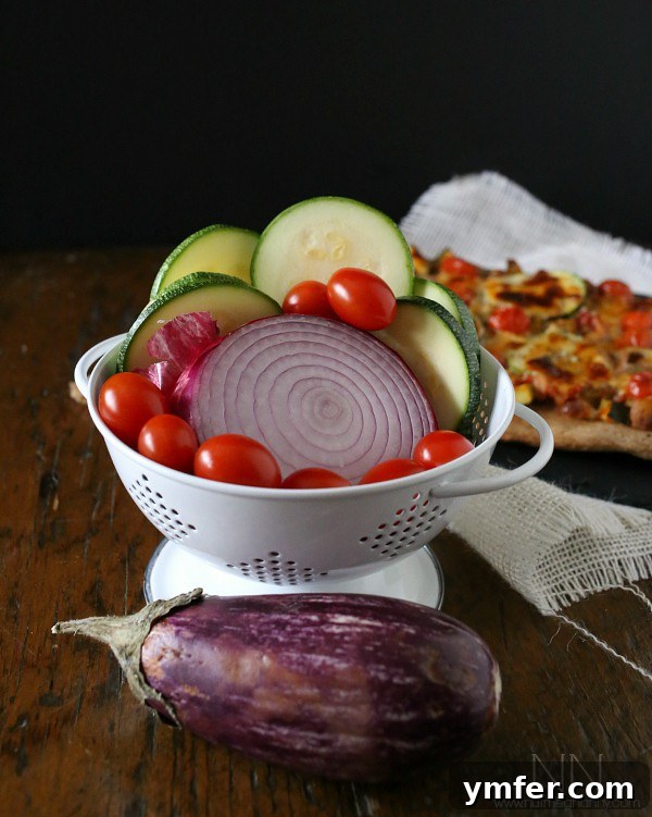 Provencal Garden Pizza 3 Fresh, colorful vegetables including zucchini, red onion, eggplant, garlic, and cherry tomatoes, perfectly prepped for making Ratatouille Pizza sauce and toppings.