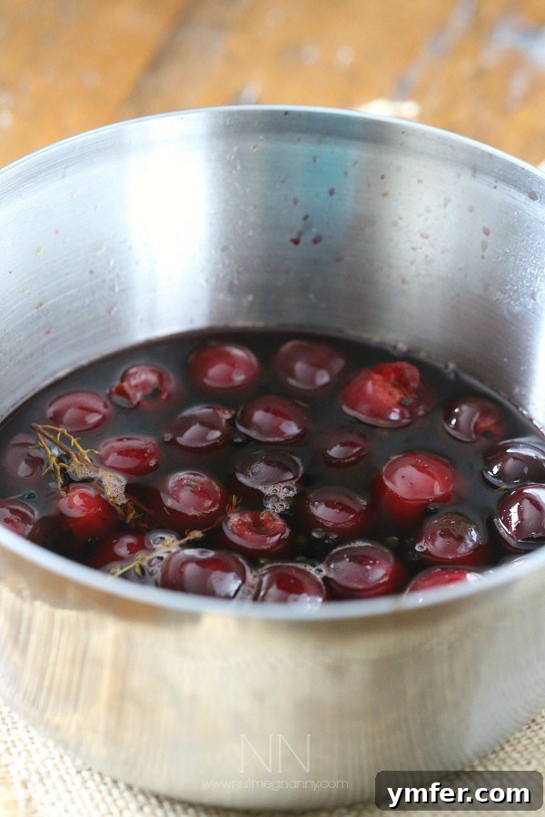 Gourmet Pickled Cherries 3 Fresh cherries and pickling liquid simmering gently in a pot on the stovetop.