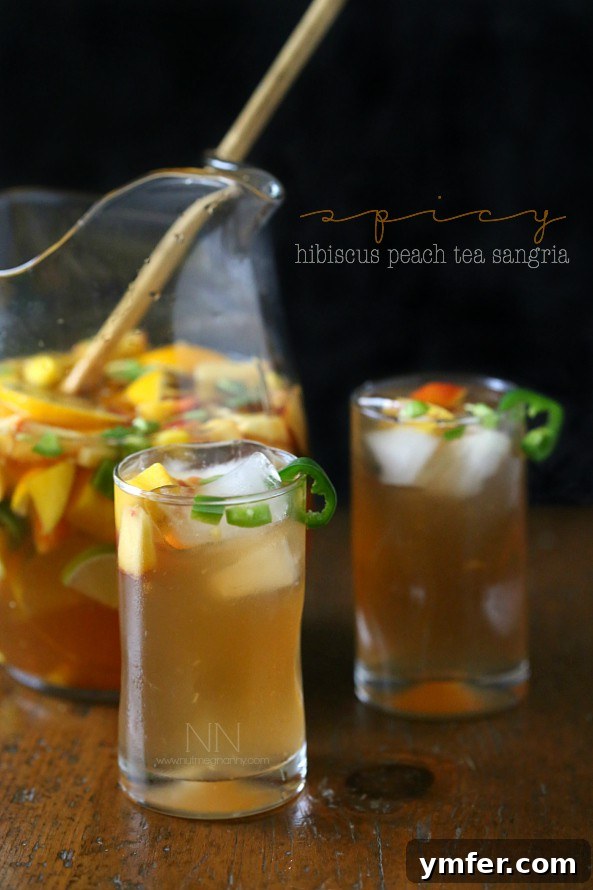 Refreshing Spicy Hibiscus Peach Tea Sangria served in a pitcher, perfect for summer gatherings