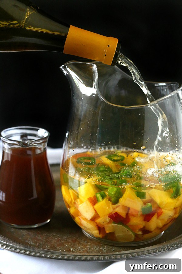 Close-up of Spicy Hibiscus Peach Tea Sangria with sliced jalapeños and peaches
