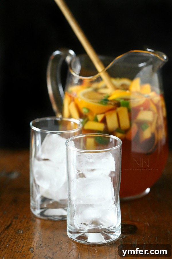 Fresh fruit including peaches, mango, orange, and lime in Spicy Hibiscus Peach Tea Sangria