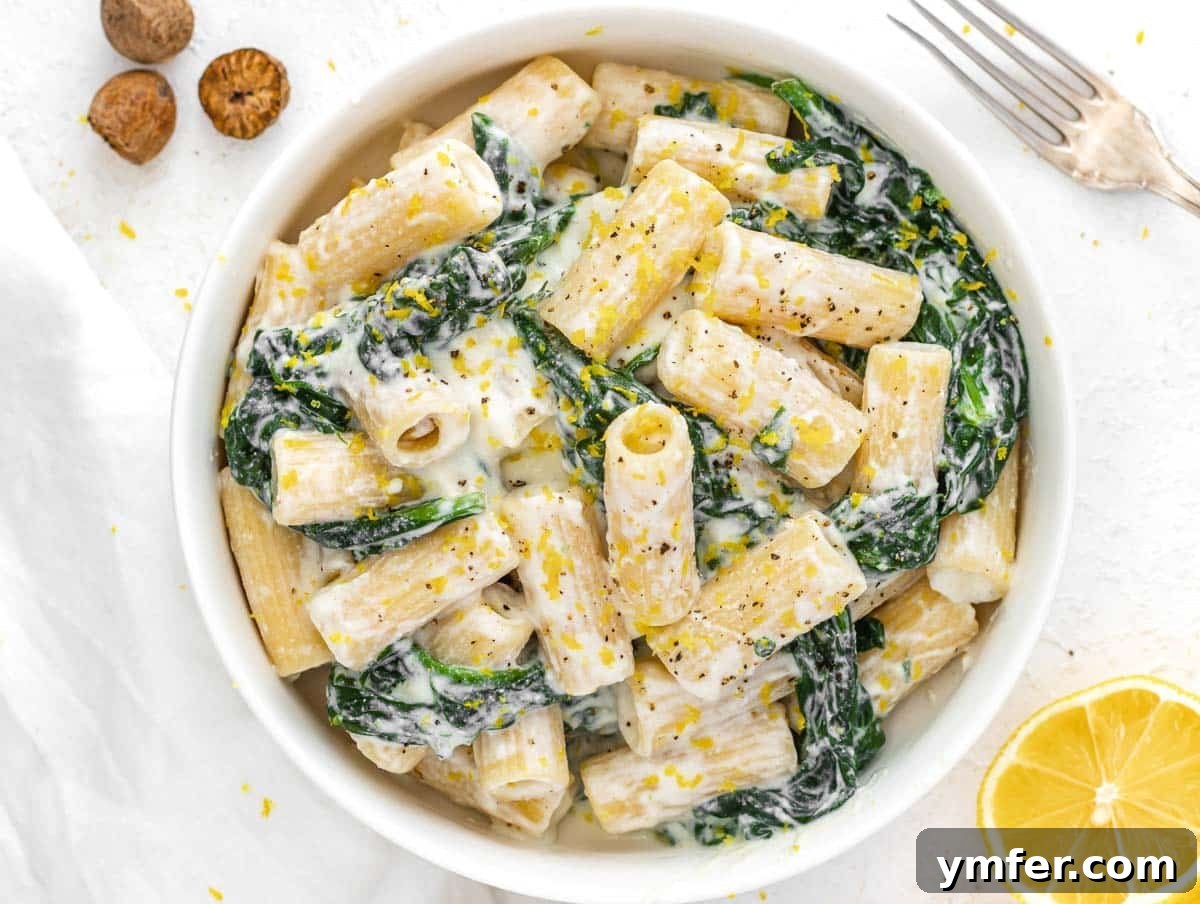 Creamy Vegan Ricotta 17 A fork twirling a delicious serving of spinach and vegan ricotta pasta, showcasing its creamy texture.