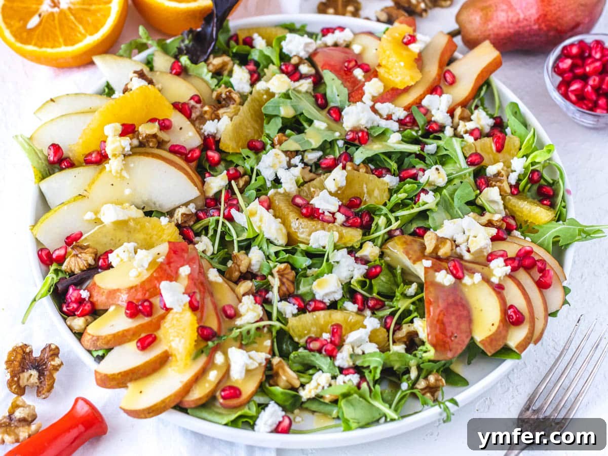 Creamy Vegan Ricotta 20 A vibrant pear salad on a plate, elegantly garnished with pomegranate seeds and crumbled vegan ricotta.