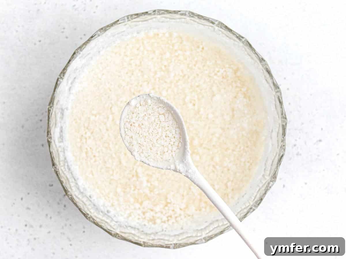 Creamy Vegan Ricotta 23 Close-up view of soy milk actively curdling in a pot, demonstrating the protein separation process.