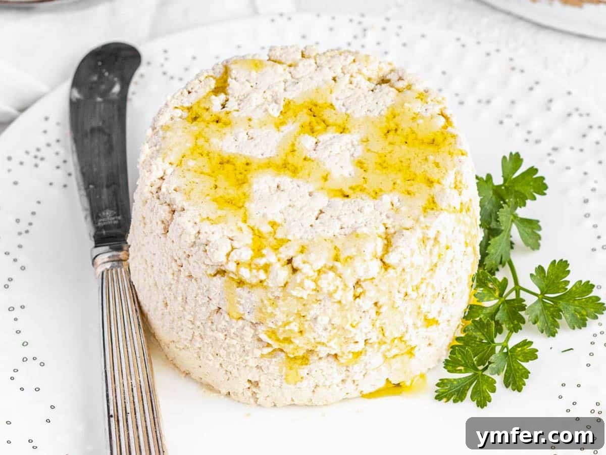 Creamy Vegan Ricotta 25 Creamy vegan ricotta made with cashew nuts, presented beautifully on a white plate with a drizzle of olive oil.