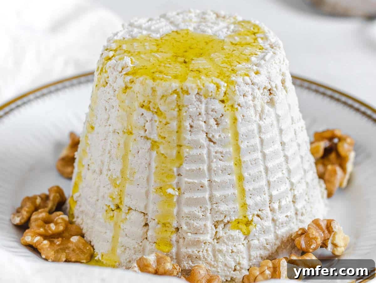Creamy Vegan Ricotta 6 A freshly molded dairy-free ricotta cheese, ready for storage, next to an airtight container.