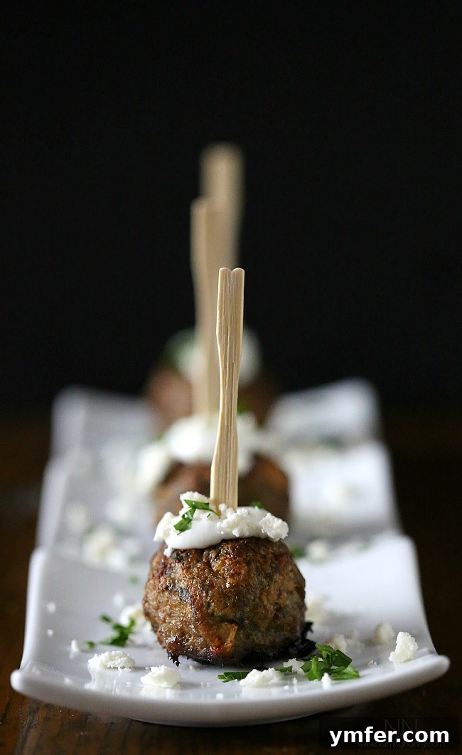 Delicious Greek Lamb Meatballs with Feta and Spices Greek Lamb Meatballs on a platter, showcasing their golden-brown exterior and delicious appeal.