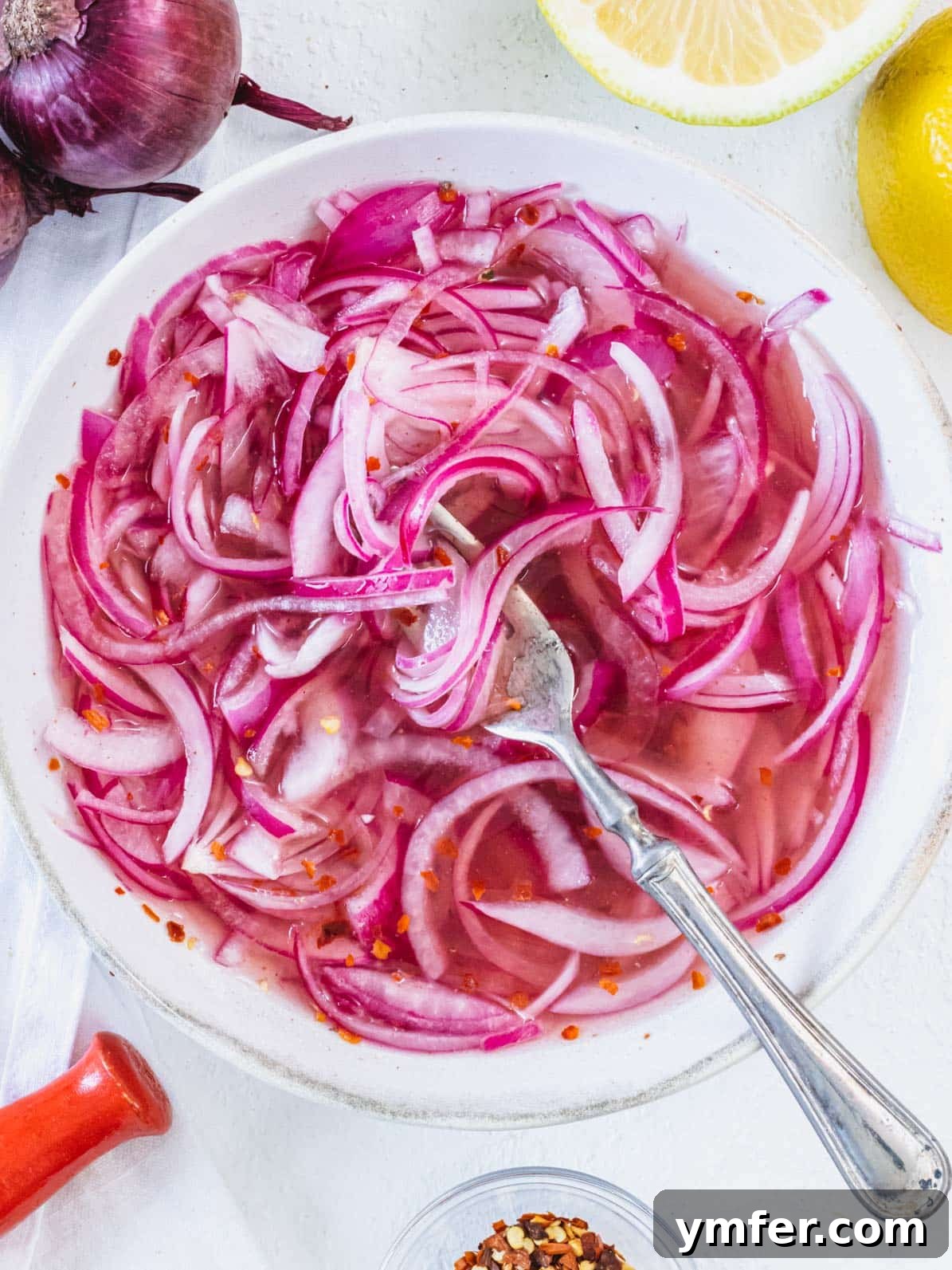 Pickled red onions with a fork