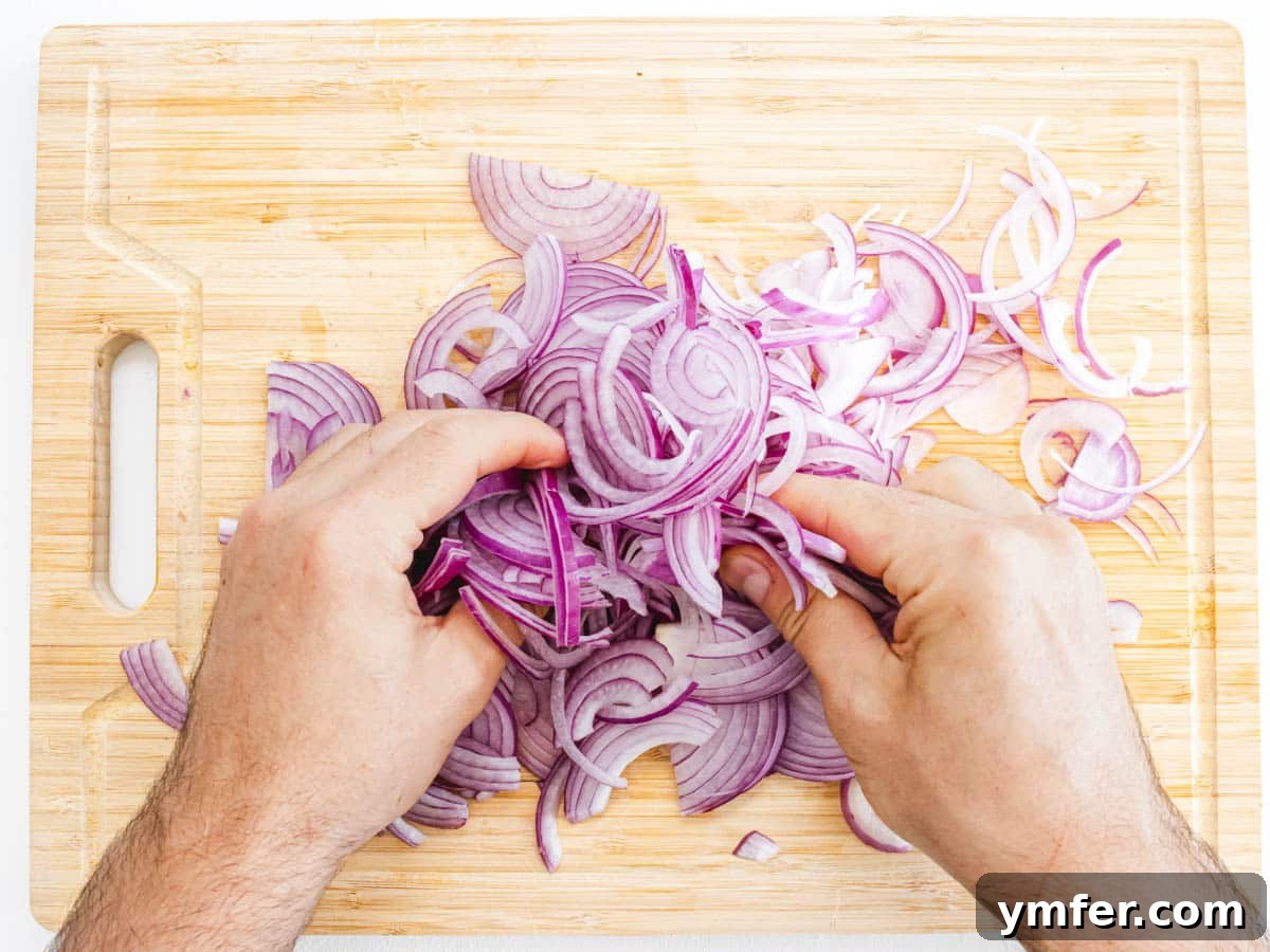 Hands massaging red onions