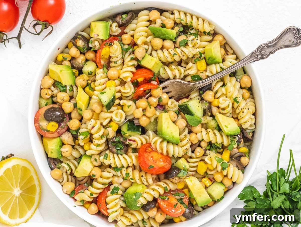 Nourishing Plant Power Meals 14 Delicious chickpea pasta salad with a fork in a bowl