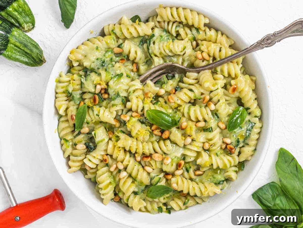 Nourishing Plant Power Meals 28 Fresh zucchini pasta with a fork and sprinkled with pine nuts