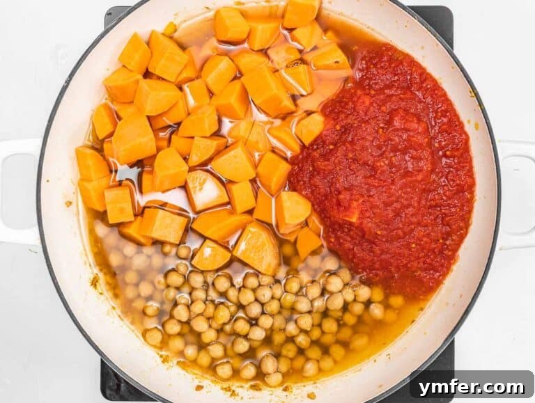 Nourishing Plant Power Meals 37 Chickpeas, diced sweet potato, and crushed tomatoes simmering in a pot