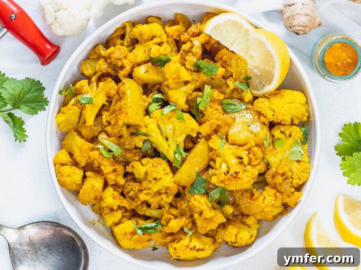 Nourishing Plant Power Meals 10 Authentic Aloo Gobi dish with fresh cilantro and a lemon wedge