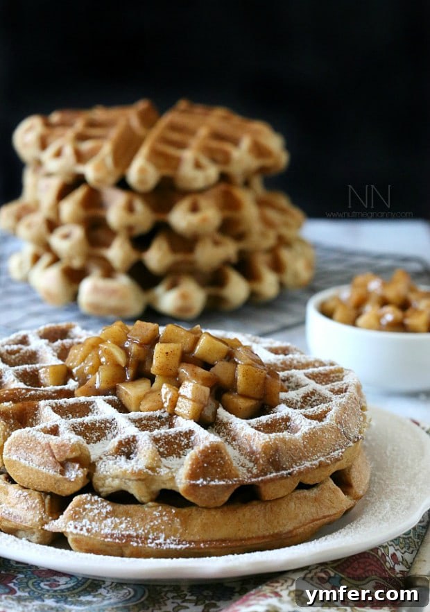 Close-up of golden-brown gluten-free apple cinnamon waffles with syrup and butter. Close-up of golden-brown gluten-free apple cinnamon waffles with syrup and butter.