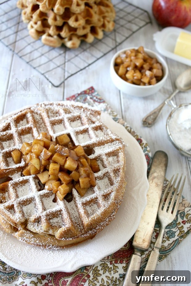 Stack of gluten-free apple cinnamon waffles with a side of warm apple topping. Stack of gluten-free apple cinnamon waffles with a side of warm apple topping.