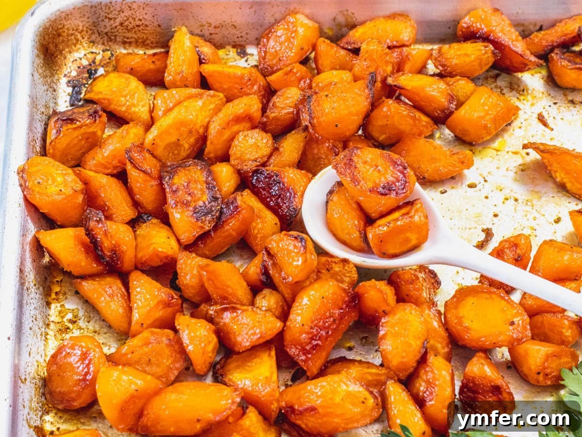 Caramelized Carrots and Crispy Brussels Sprouts 14 A dish of perfectly glazed roasted carrots with a white spoon.