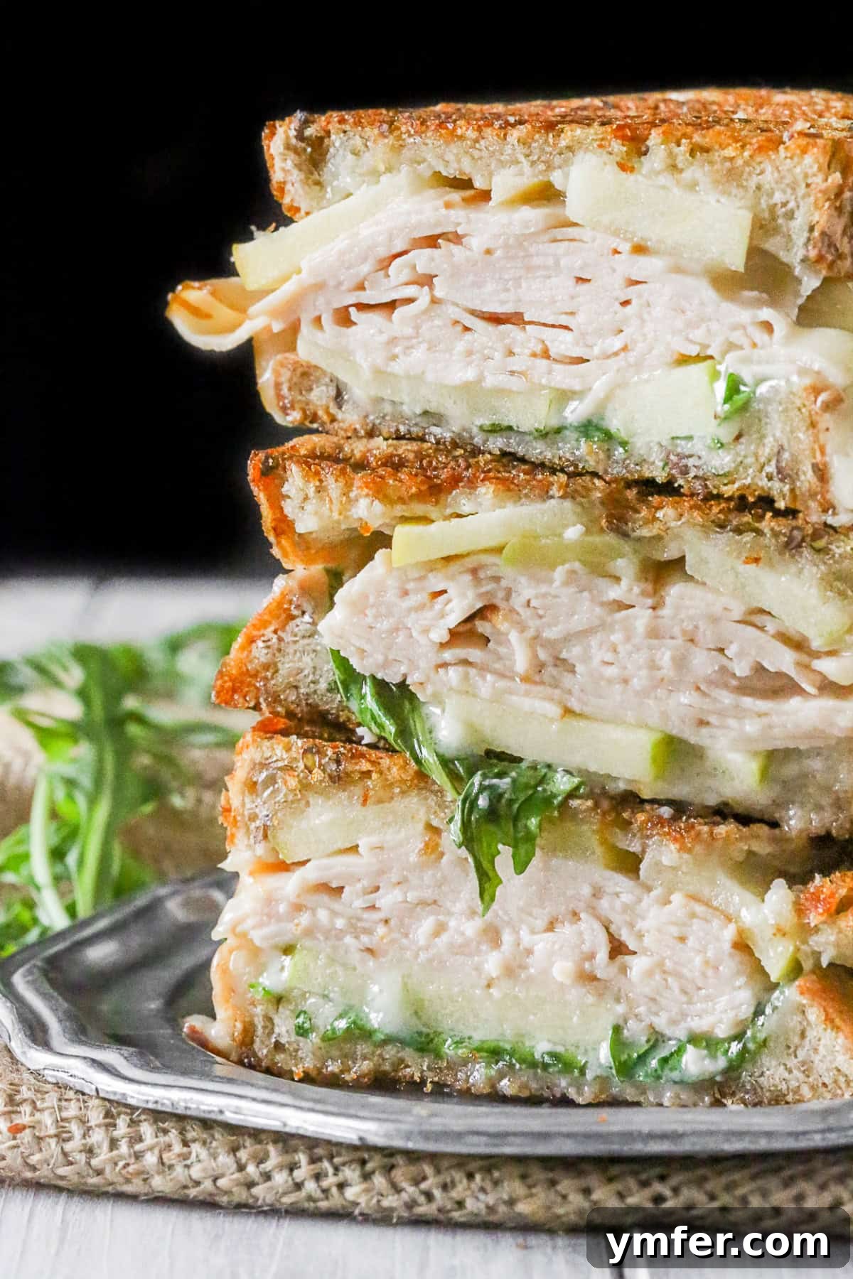 Gourmet Turkey Apple Brie Panini 2 Turkey Apple Brie Panini cut and stacked on a plate, showcasing melted Brie and crisp apple slices.