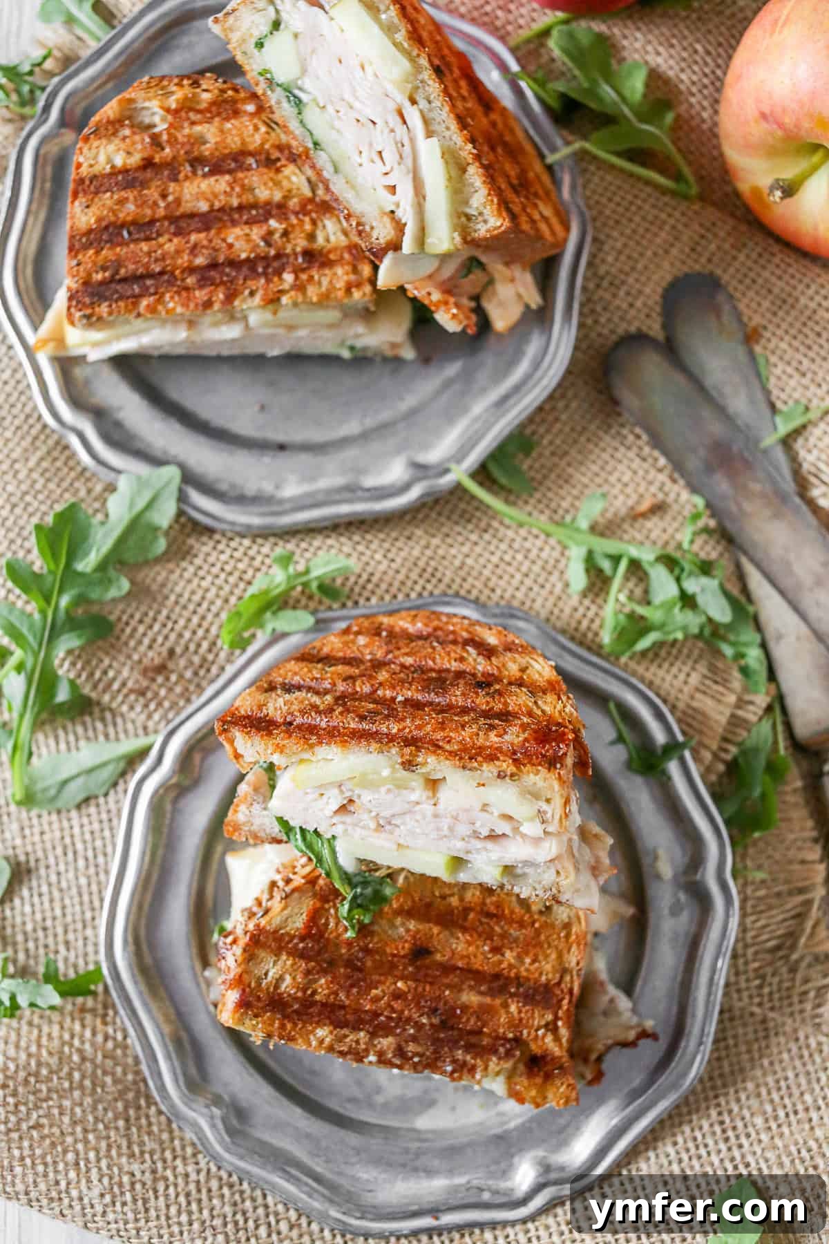 Gourmet Turkey Apple Brie Panini 3 A delectable Turkey Apple Brie Panini served on a plate, showcasing its golden-brown bread and inviting fillings.
