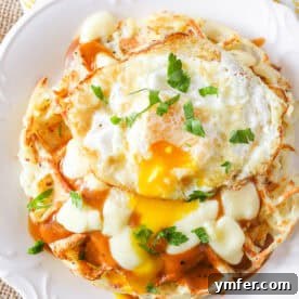 Waffled Hash Brown Poutine 3 Crispy Poutine Hash Brown Waffles topped with a fried egg, ready to be served for a delightful meal.
