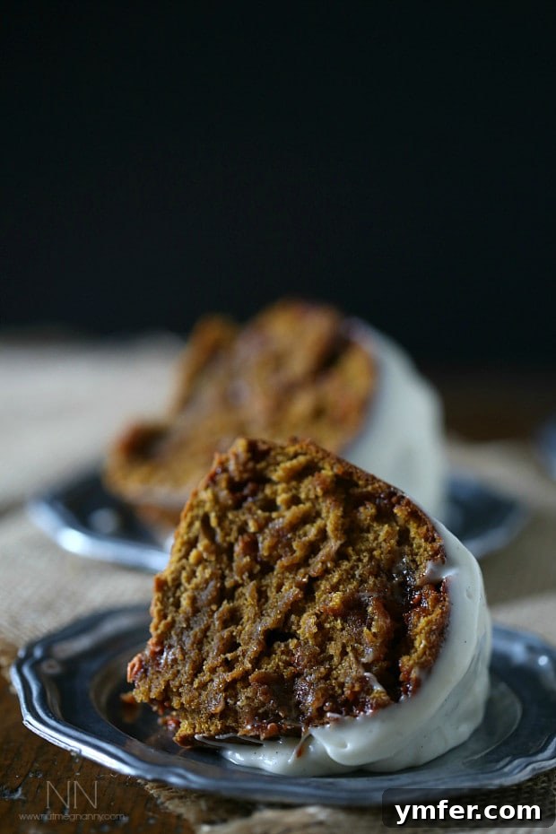 A delicious slice of butterscotch pumpkin bundt cake. A close-up slice of Butterscotch Pumpkin Bundt Cake, showcasing its moist texture, visible butterscotch chips, and generous cream cheese glaze.