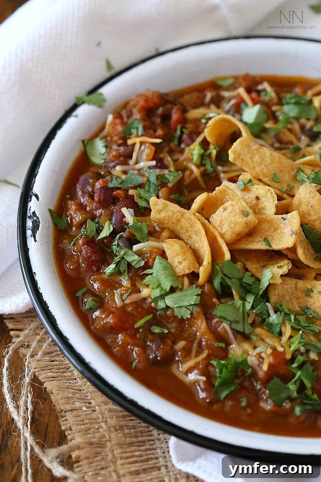 Delicious Slow Cooker Pumpkin Chili with Beans and Vegetables Close-up of Slow Cooker Pumpkin Chili in a bowl, showing the rich color and chunky texture of the pumpkin, sausage, beans, and vegetables.