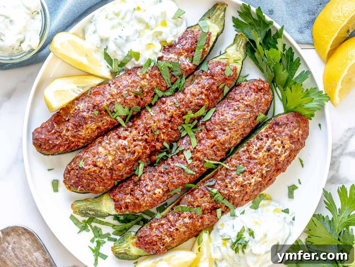 Streamline Your Week with Vegetarian Meal Prep 25 Delicious zucchini boats topped with tzatziki and fresh herbs on a plate, a healthy and creative meal idea.