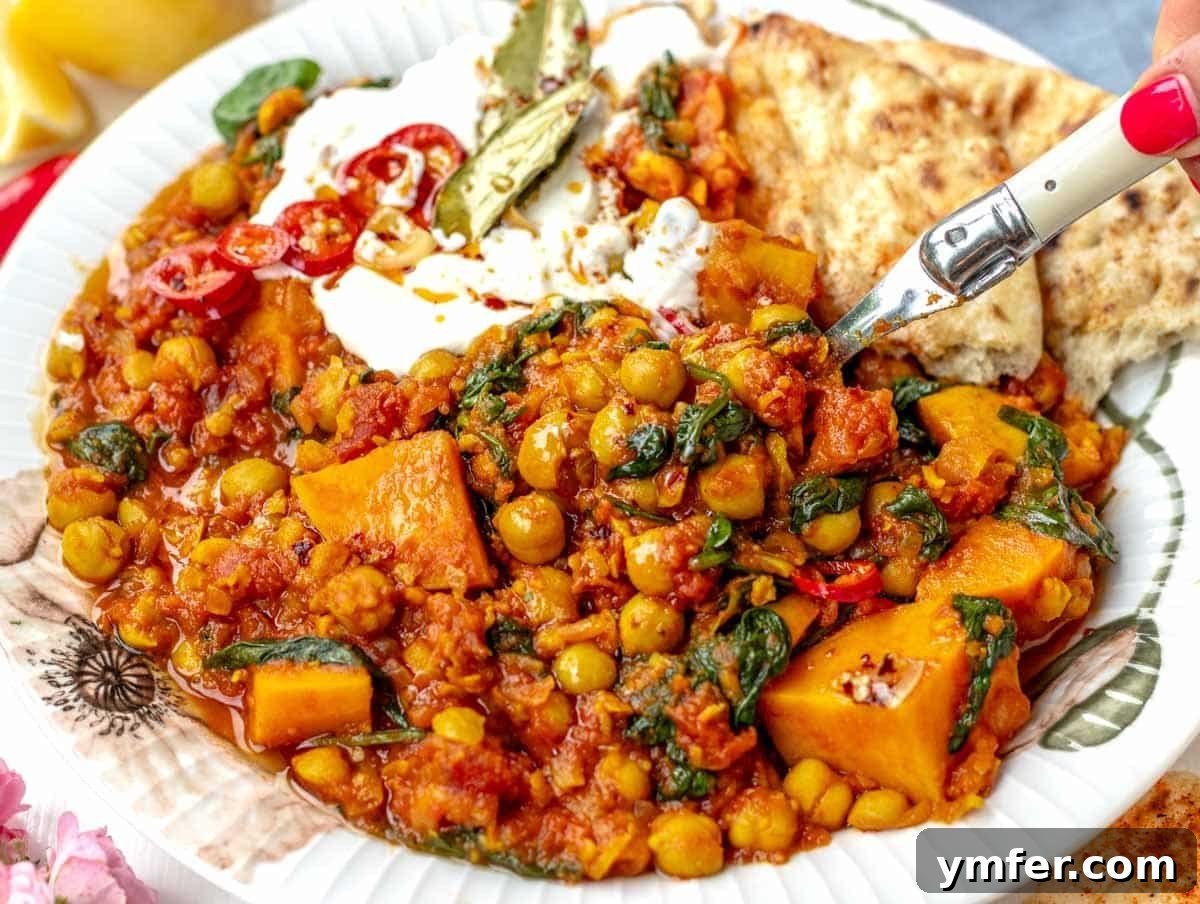 Streamline Your Week with Vegetarian Meal Prep 30 Hearty chickpea stew being served with a female hand holding a spoon, indicating a fulfilling and warm meal.