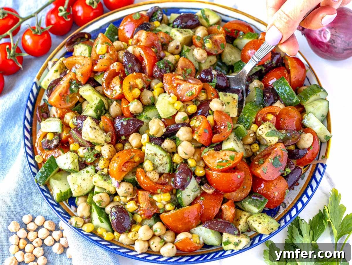 Streamline Your Week with Vegetarian Meal Prep 10 A hand holding a spoon in a bowl of creamy chickpea salad, showcasing a delicious and easy vegetarian meal.