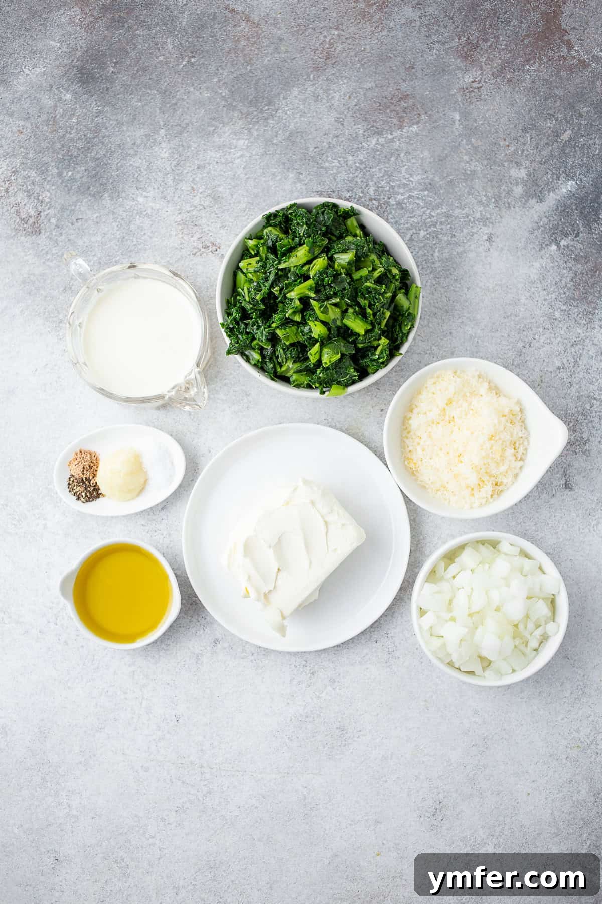 This totally simple creamed kale is the perfect Thanksgiving side dish. Full of healthy kale, cream cheese and a sprinkling of Parmesan cheese. Hello delicious! Ingredients to make Creamed Kale on a table.